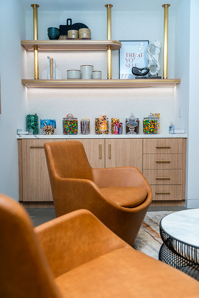 Chairs around a coffee table and a shelf with jars of candy